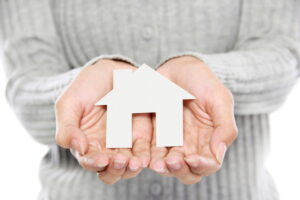 portrait of Hands of woman holding white paper house